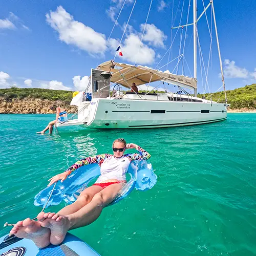 Young woman floating in raft on Caribbean sailing vacations